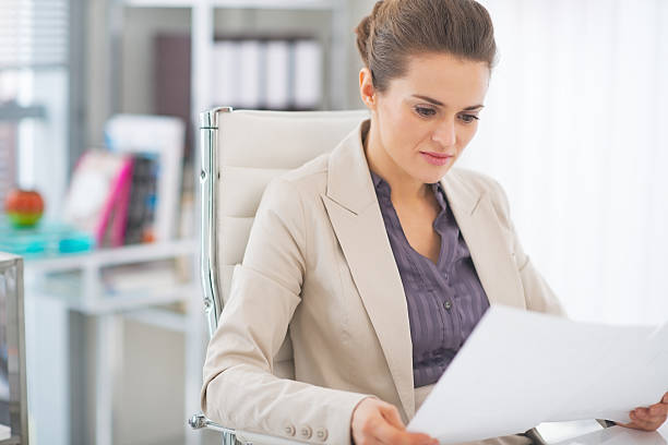 istock happy business woman examining documents in office 508379703