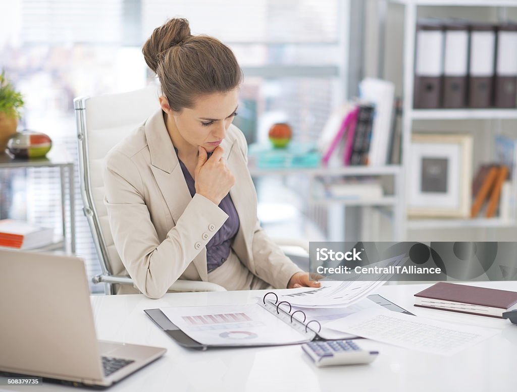 thoughtful business woman documents in office Thoughtful business woman documents in office Adult Stock Photo