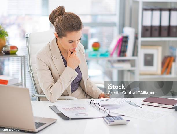 Thoughtful Business Woman Documents In Office Stock Photo - Download Image Now - Adult, Budget, Business