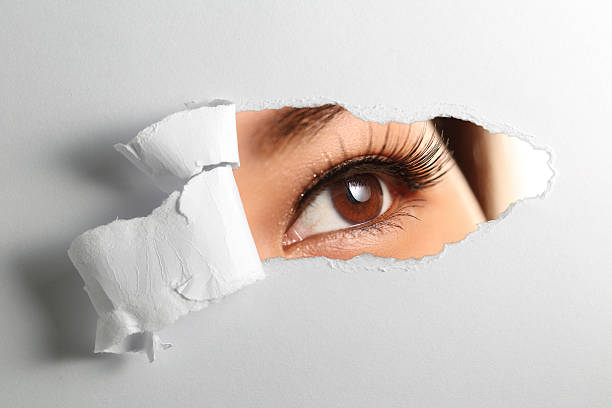 istock woman looking through torn paper 508380990