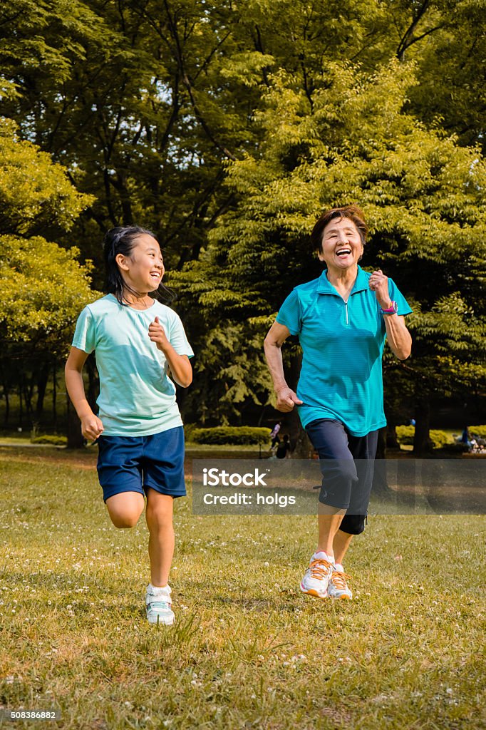 Japanese girl and grandmother running in the park Active Lifestyle Stock Photo