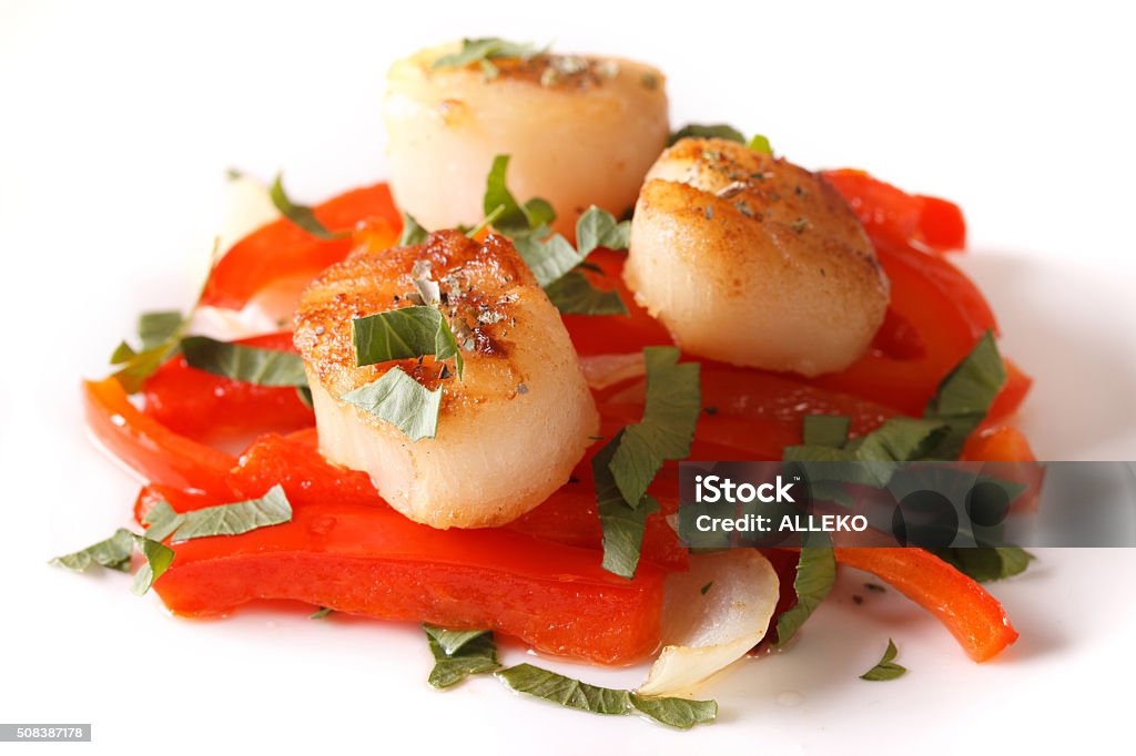 fried scallops with red pepper close-up on a plate. Horizontal fried scallops with red pepper and parsley close-up on a plate. Horizontal Appetizer Stock Photo