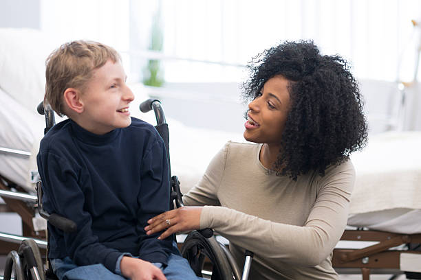 Happy Child with Cerebral Palsy A physical therapist is working with a child in the hospital that has cerebral palsy. developmental disability stock pictures, royalty-free photos & images
