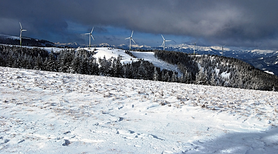 Murzzuschlag-Pretul wind park (wind farm) in winter Fischbacher Alpen in Styria with panorama of higher peaks of winter austrian alps on the background