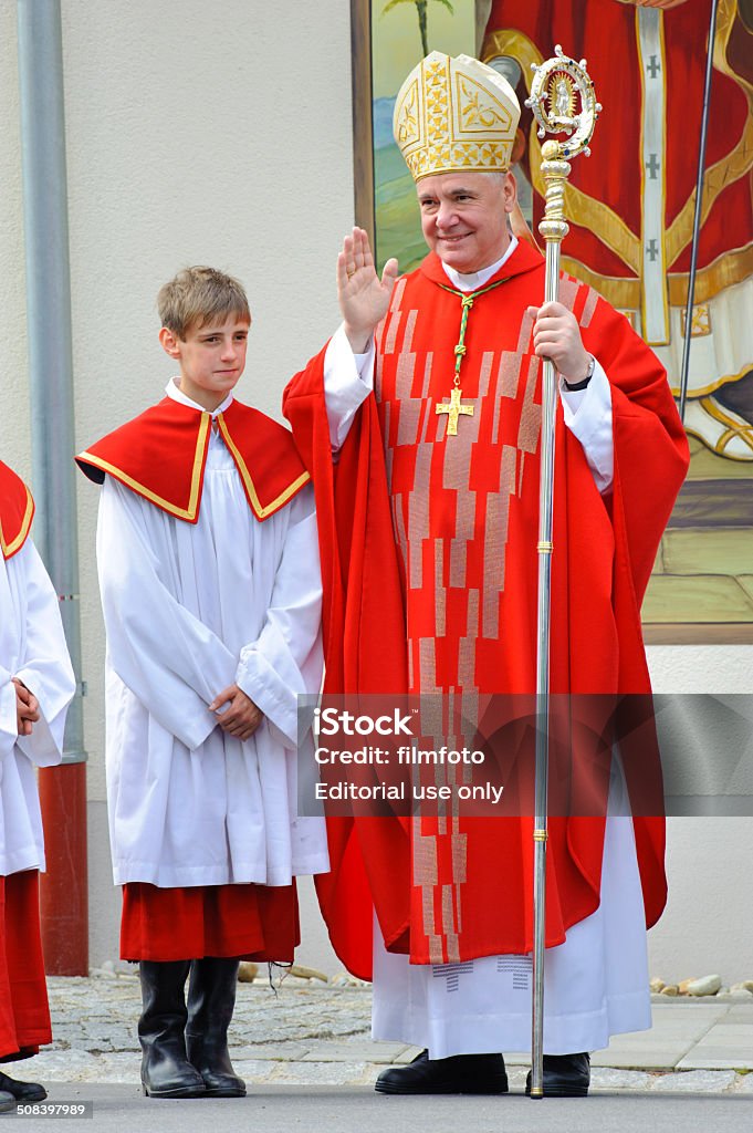 Bishop and cardinal Gerhard Ludwig Müller Bad Kötzting, Germany - June 13, 2011: Every year at pentecost a traditional catholic horse procession takes place from a church inside city Bad Kötzting to a church in village Steinbühl. At this church the German catholic bishop Gerhard Ludwig Müller of diocese Regensburg with young unidentified ministrant gives the blessing to the participating riders and horses. Since 2014 Müller has been appointed to cardinal in Vatican, Rom. Bishop - Clergy Stock Photo