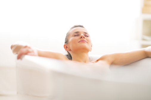 Relaxed young woman laying in bathtub