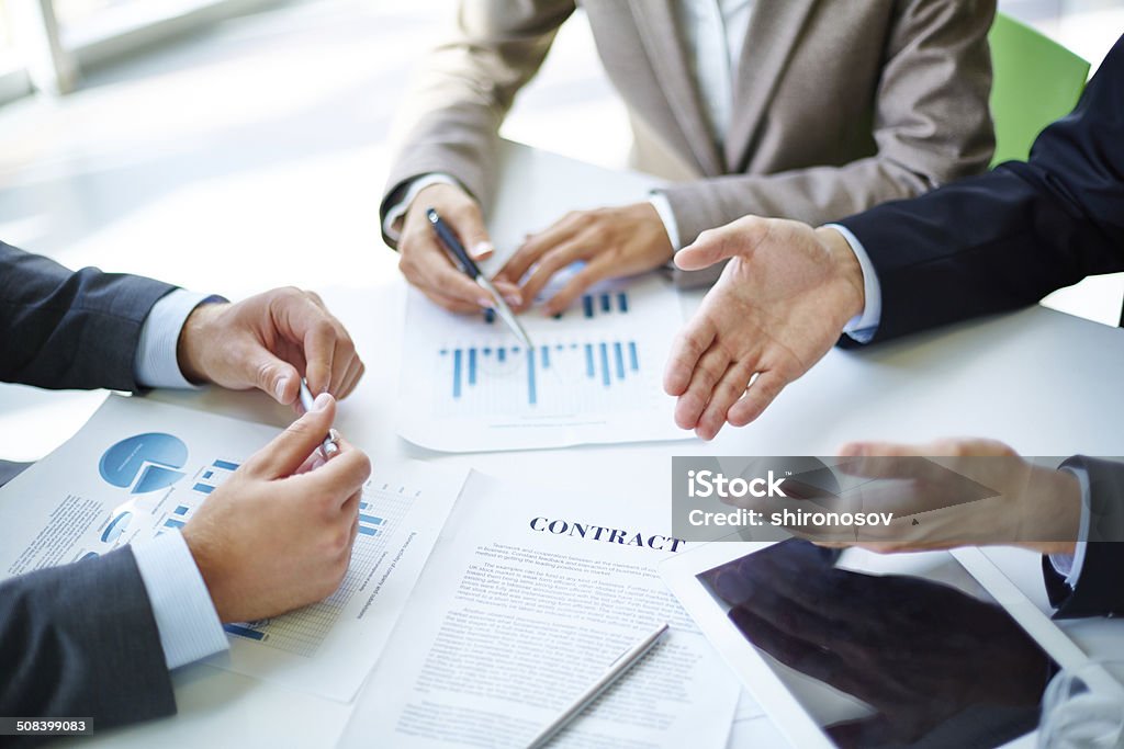 Negotiations Image of business partners hands over business objects on workplace at meeting Achievement Stock Photo