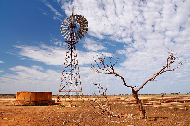 mulino a vento pompa dell'acqua nell'entroterra australiano - entroterra foto e immagini stock