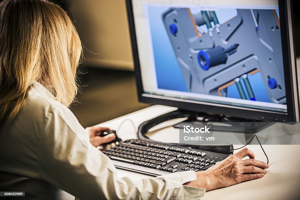 Engineer Working on Desktop Computer Female engineer working on a computer in the office. Product Designer Stock Photo