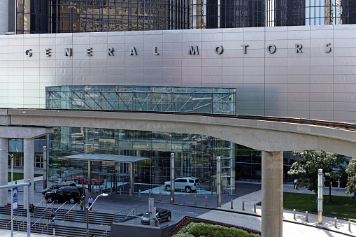 Detroit, MI, USA – July 31, 2014: People exit the General Motors World Headquarters building located in Detroit, Michigan. General Motors is an American multinational automobile corporation.