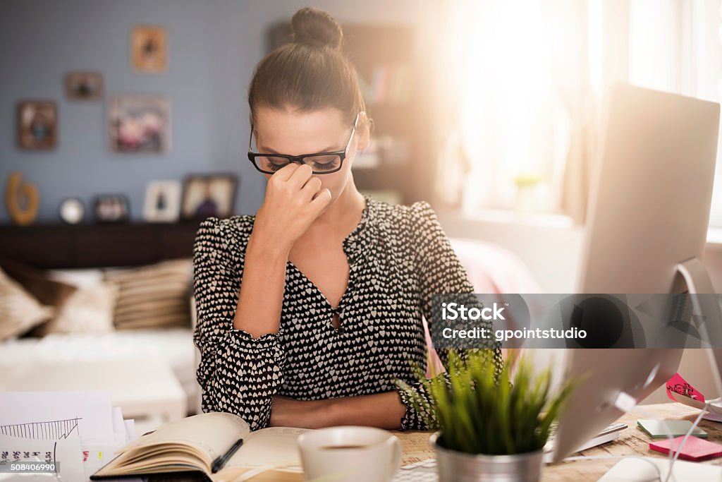 Strong headache during work at the office Head In Hands Stock Photo