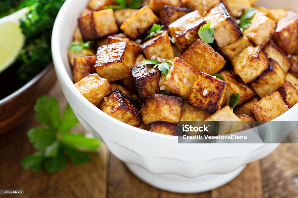 Stir fried tofu in a bowl Stir fried tofu in a bowl with sesame and greens Baked Stock Photo