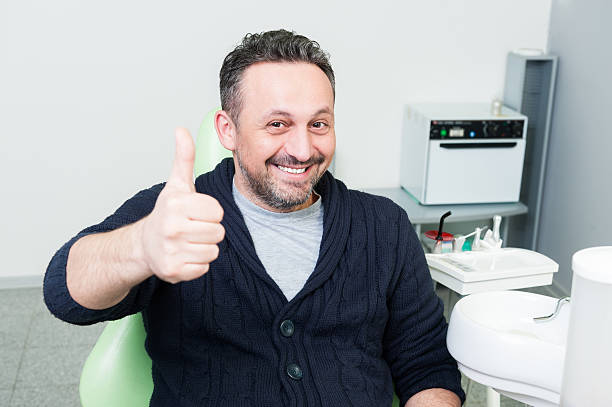 istock Smiling patient sitting happy on dentist chair 508413876
