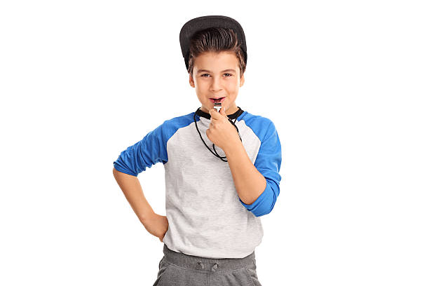 Cheerful boy in sportswear blowing a whistle Cheerful boy in sportswear blowing a whistle and looking at the camera isolated on white background whistling stock pictures, royalty-free photos & images