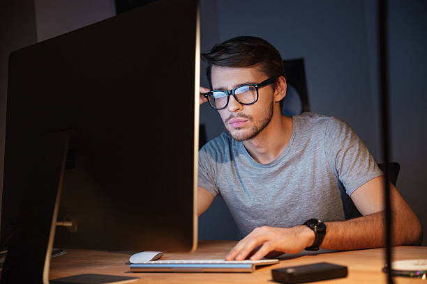 istock Thoughtful man thinking and working with computer in dark room 508418484