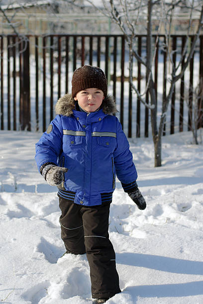 istock Boy in blue jacket running through the snow 508419012