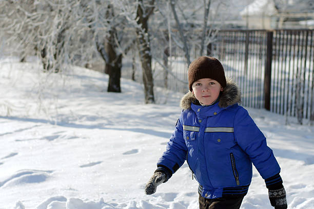 istock Boy in blue jacket running through the snow 508419036