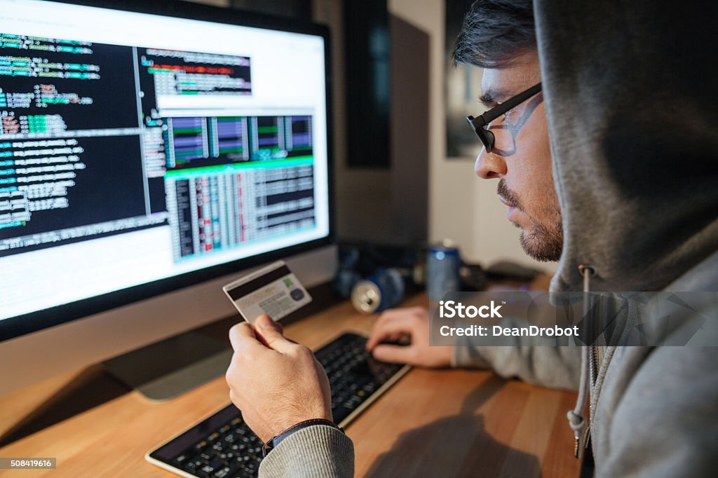Konzentrierte Hacker in Brille stehlen Geld von diferent Kreditkarten - Lizenzfrei Bankkarte Stock-Foto