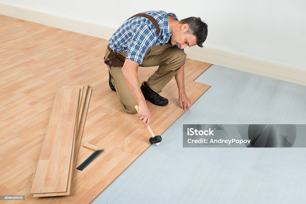 Man Installing New Laminated Wooden Floor Carpenter Installing New Laminated Wooden Floor At Home Flooring Stock Photo