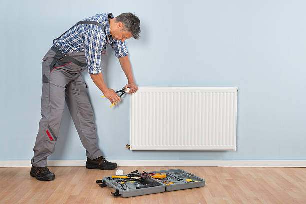 istock Male Plumber Repairing Radiator 508420634