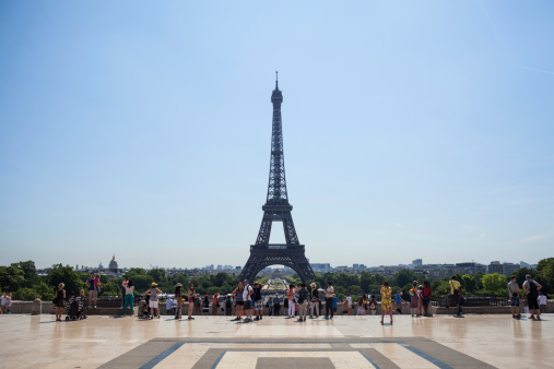 Paris, France - July 31, 2014: The Eiffel Tower; Tourists watching Eiffel tower from the Place du Trocadéro, image taken in summertime during tourist season.