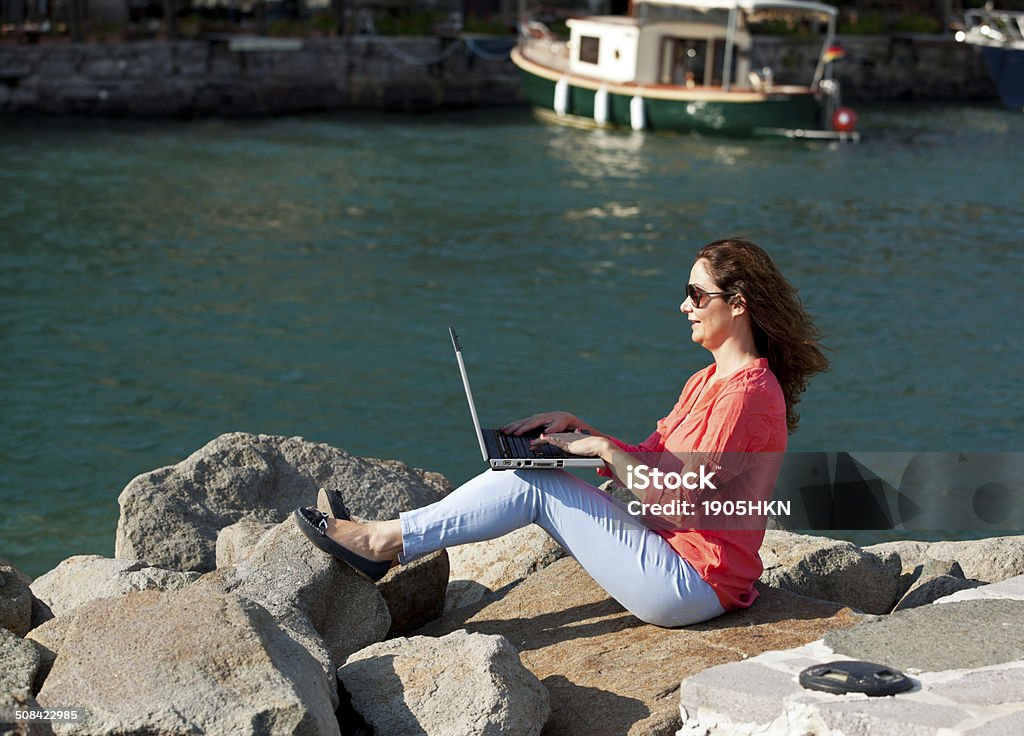 Young woman using laptop young woman working on laptop on the pier  Adult Stock Photo