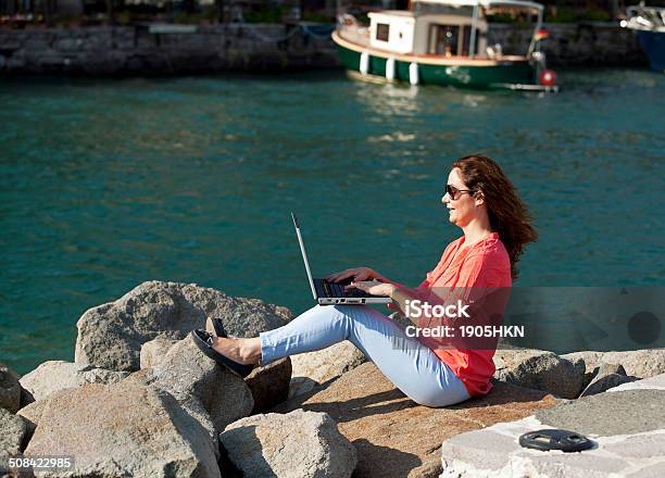 Young Woman Using Laptop Stock Photo - Download Image Now - Adult, Aspirations, Beach