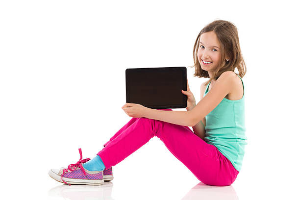 Happy girl presenting a digital tablet stock photo