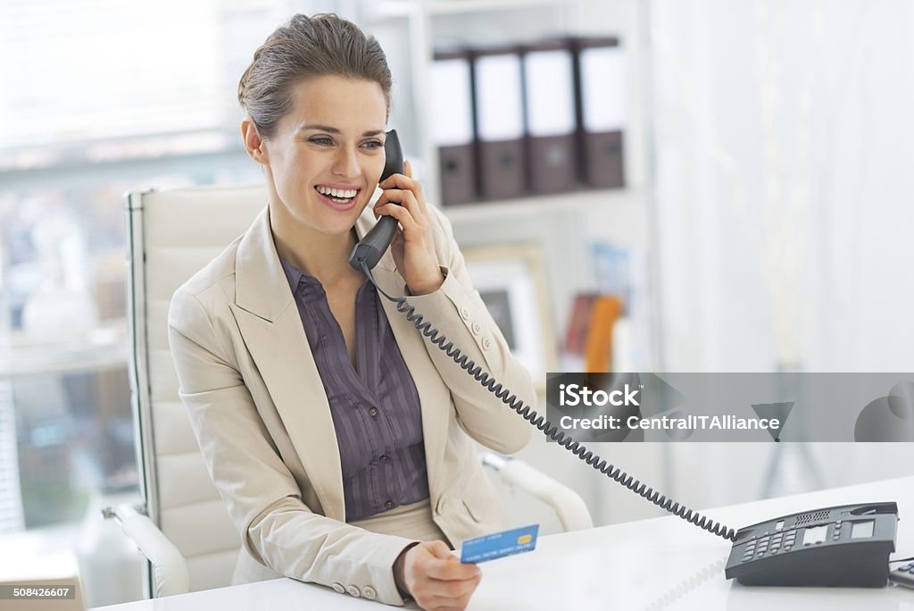 smiling business woman talking phone in office Smiling business woman talking phone in office Adult Stock Photo
