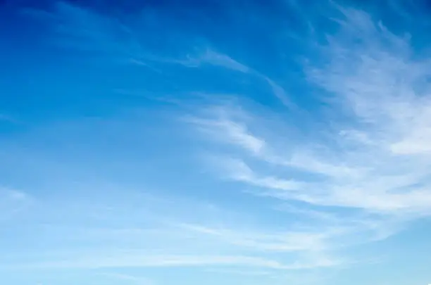 Wispy, thin cirrus clouds against blue sky