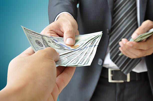 Hands giving & receiving money - United States Dollars (USD) Hands giving & receiving money - United States Dollars (or USD) bills begging social issue photos stock pictures, royalty-free photos & images