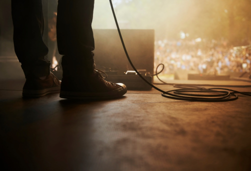 Cropped shot of a musician's feet on stage at an outdoor music festival