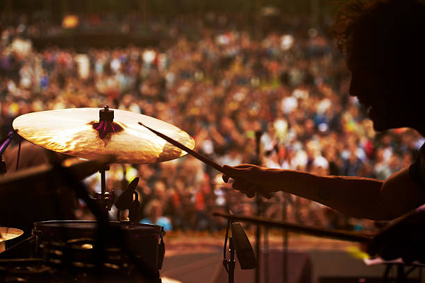 Taking to the stage Cropped shot of a drummer playing in front of a large crowd at an outdoor music festival drummer stock pictures, royalty-free photos & images
