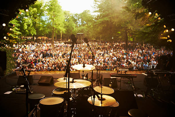 Ready to go on stage Shot of musical instruments on a stage looking out over a huge crowd microphone stand stock pictures, royalty-free photos & images