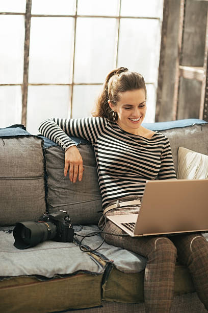 istock Smiling young woman with modern dslr photo camera using laptop 508443201