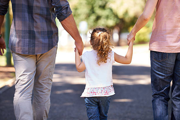 Rear view shot of a young family walking down the street