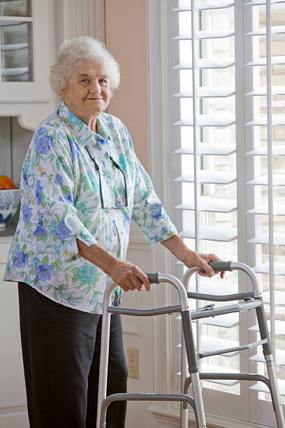 istock Senior Elderly Female with Metal Walker Standing at Window 508445133