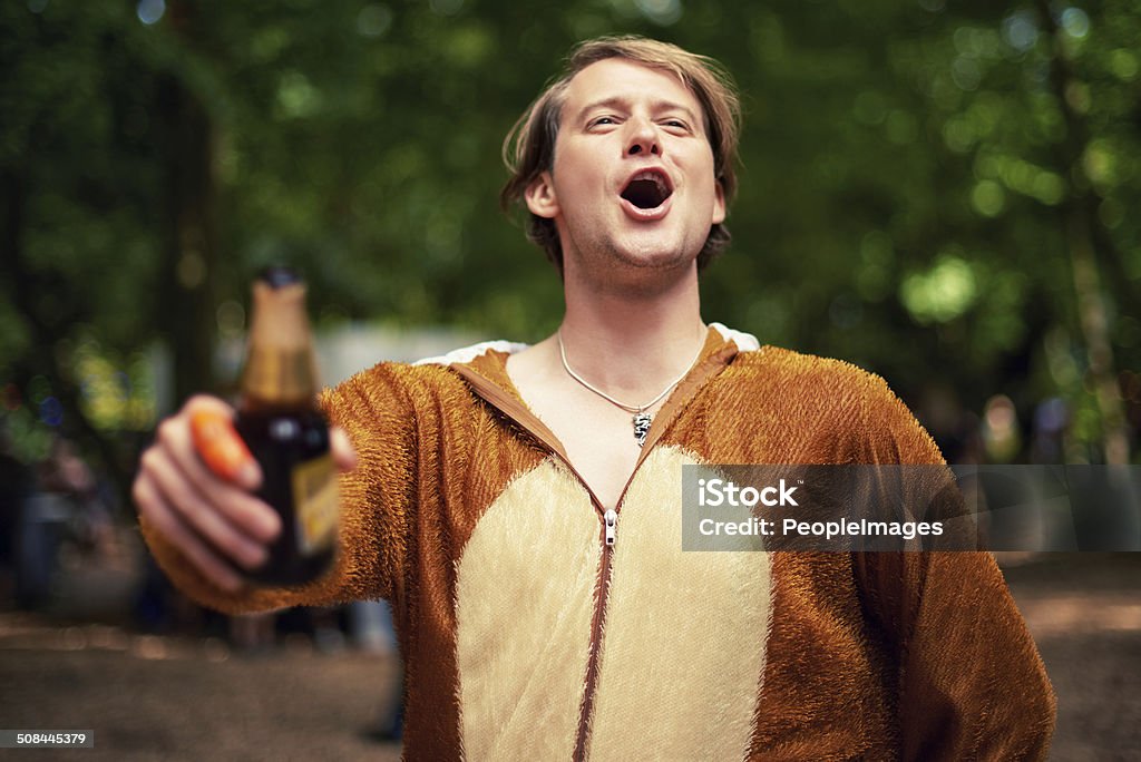 Behold the party animal Shot of a young man drinking outside while dressed in a bear suit Drunk Stock Photo