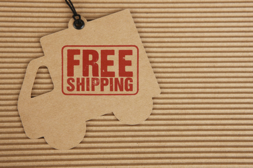 Free Shipping stamped on cardboard delivery truck on corrugated cardboard background.