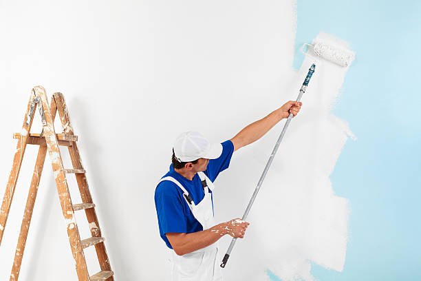 painter painting with paint roller stock photo