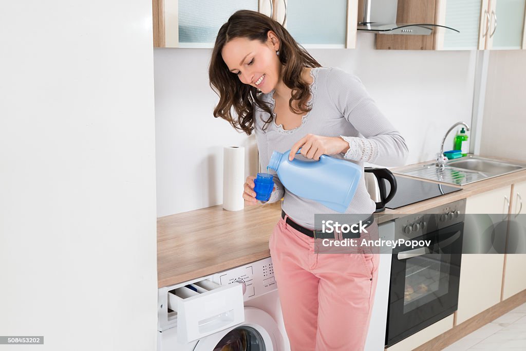 Frau gießen flüssige Waschmittel In die Bottle Cap - Lizenzfrei Frauen Stock-Foto