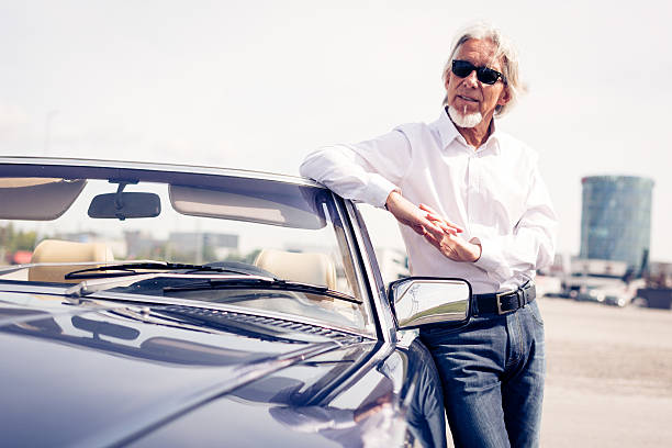 istock senior man standing next to convertible classic car 508454206