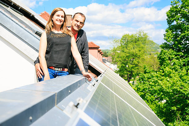 home owners are happy with solar panels on his roof these home owners are happy with the solar panels on their roof. they save a lot of money by generating their own electricity. solar power station solar panel house solar energy stock pictures, royalty-free photos & images