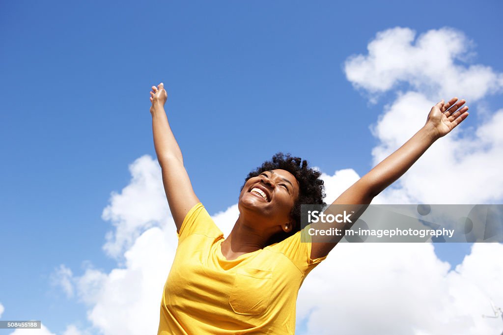 Allegra giovane donna con le mani sollevate verso il cielo - Foto stock royalty-free di Felicità