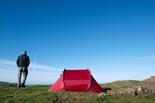istock Camping, Man with red tent on the Cornish Coast 508455692