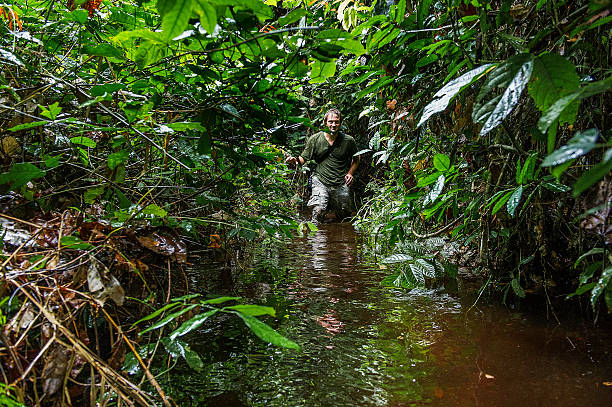 istock Photographer in the jungle goes through a bog 508458938