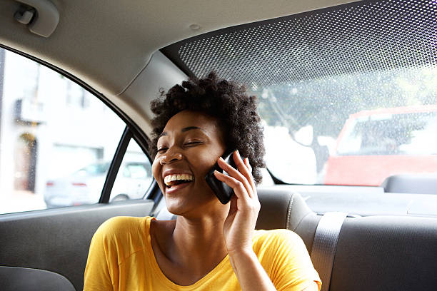 rindo mulher jovem em um carro falando no celular - candid talking beautiful casual - fotografias e filmes do acervo