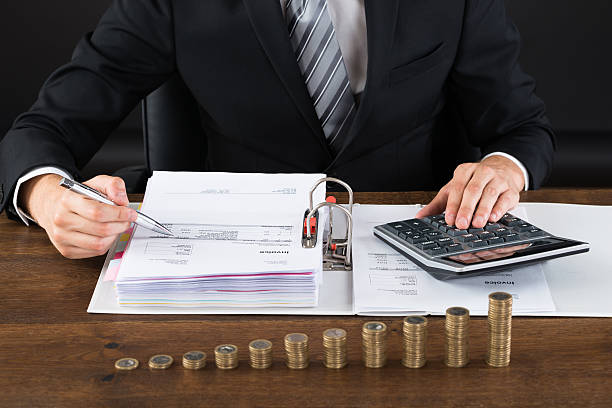 istock Businessman Calculating Invoice With Coins At Desk 508459982