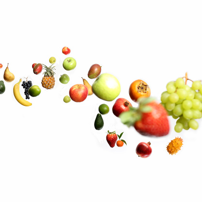 Falling or flying fruits , selective focus. The fruits fall from the left of image  to the bottom right in an elegant curve. The selective focus technique  give more realism to the movement and a 3D effect.