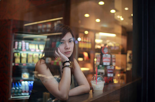 istock Young girl looking out behind the cafe window 508466759